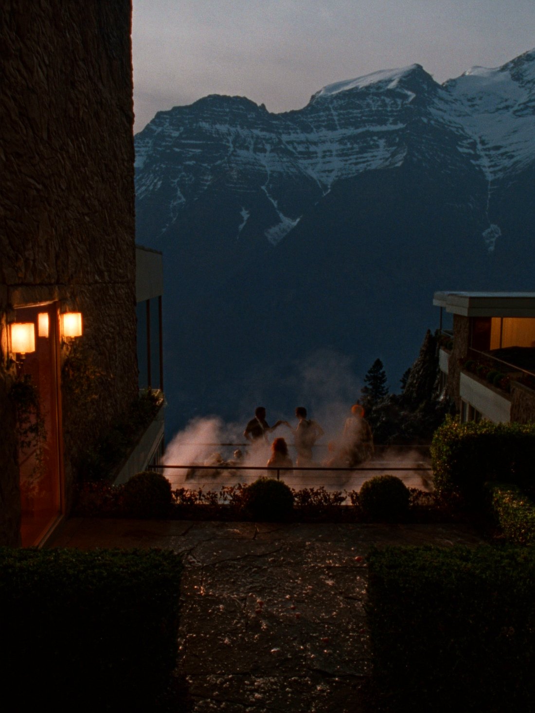 A cliffside hot spring steaming at dusk in Banff