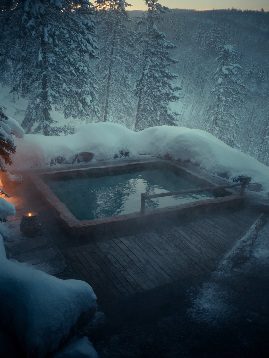 A steaming outdoor onsen in the Niseko snow at dusk