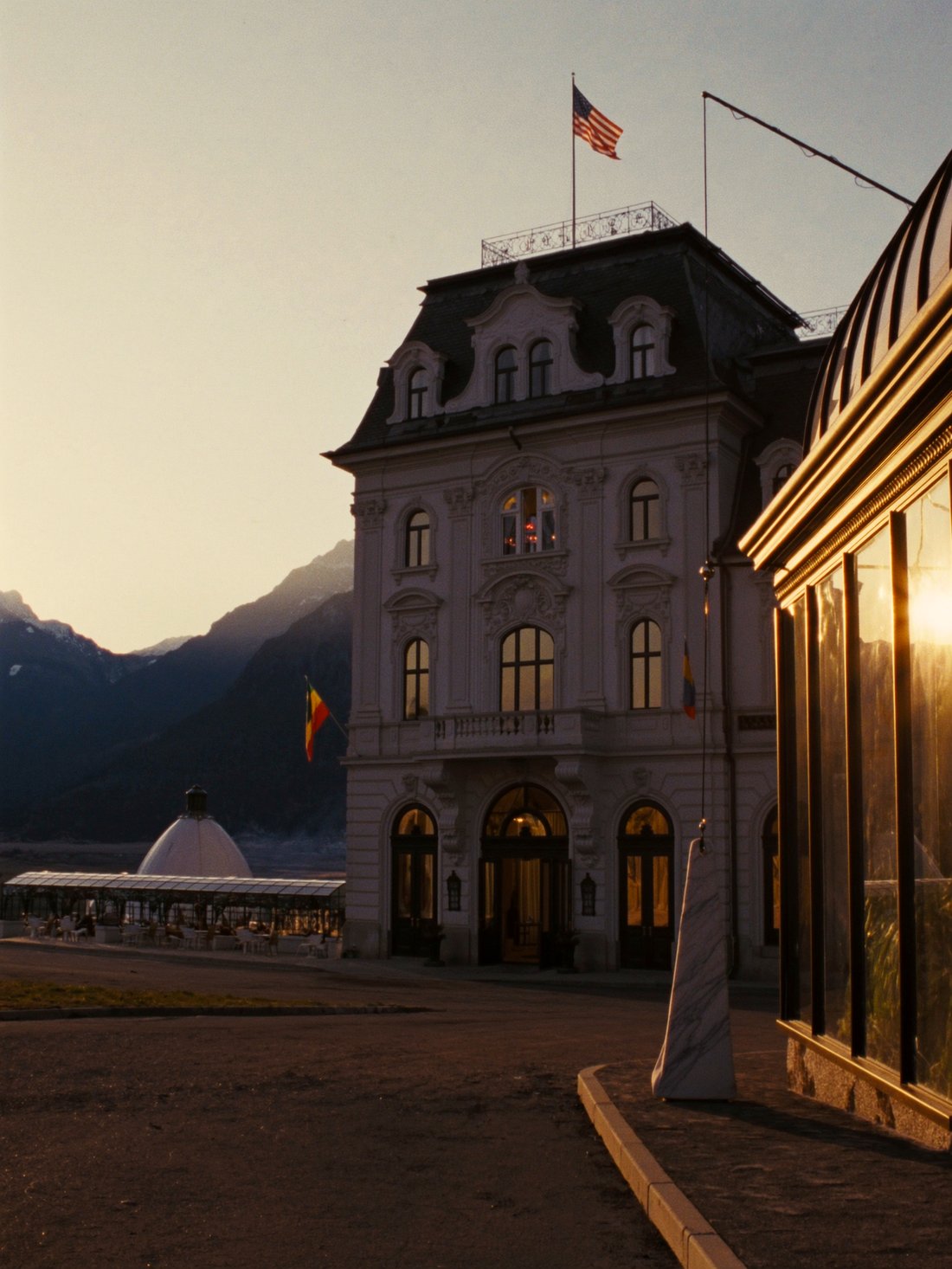 A grand St. Moritz hotel and terrace at golden hour