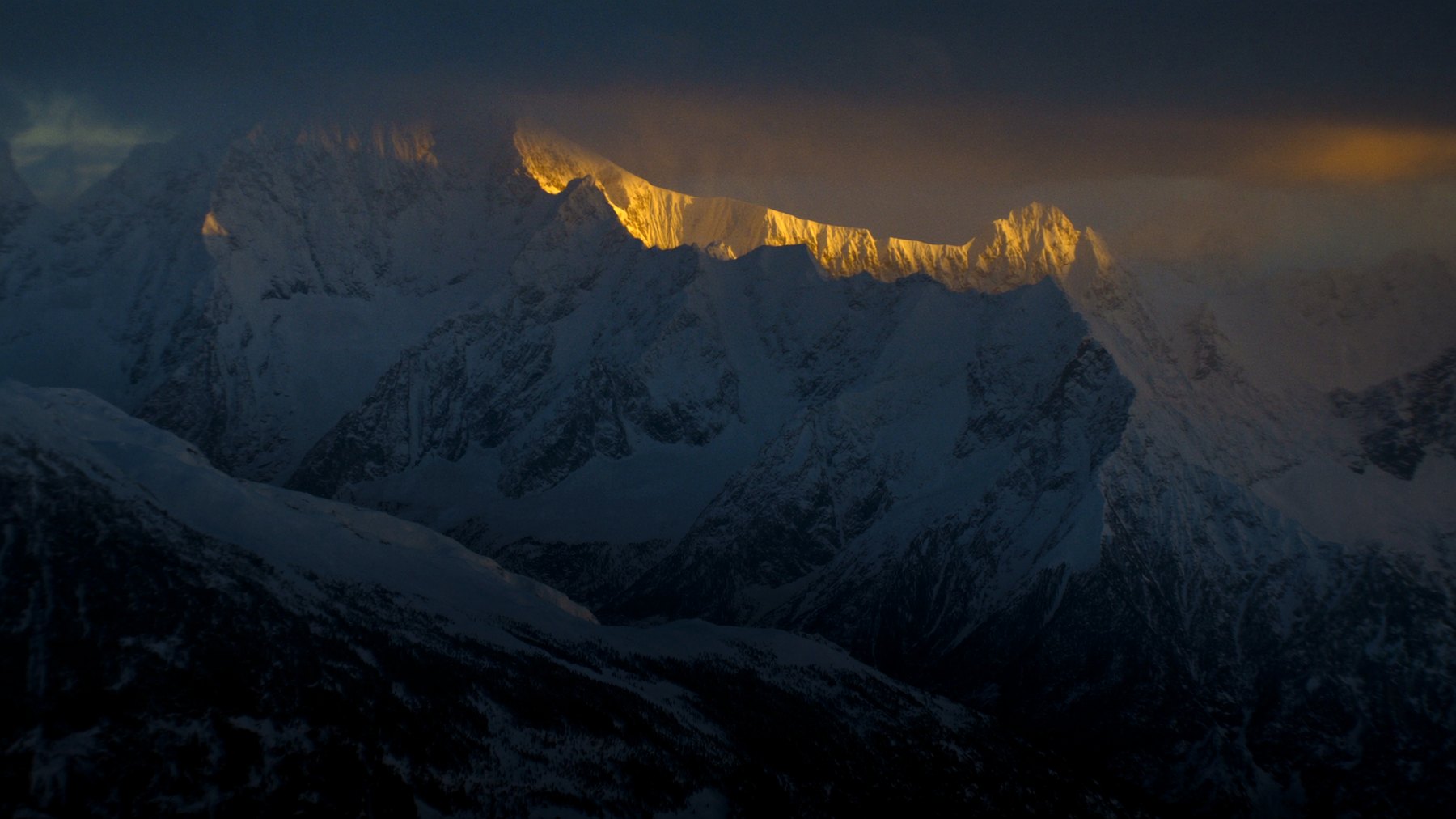 Dramatic snow-covered alpine peaks at blue hour